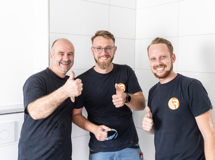 Drei Mitarbeiter von Rieber Haustechnik lächeln gutgelaunt in die Kamera
